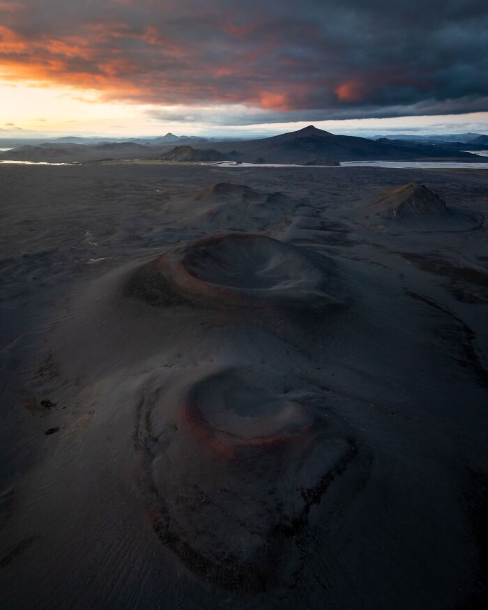 Aerial view of rugged volcanic landscape at sunset, capturing the untamed beauty of nature with dramatic skies.