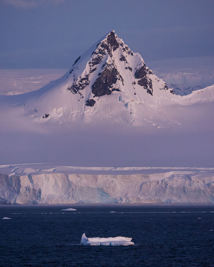 Snowy mountain peak with icebergs in foreground, showcasing untamed nature.