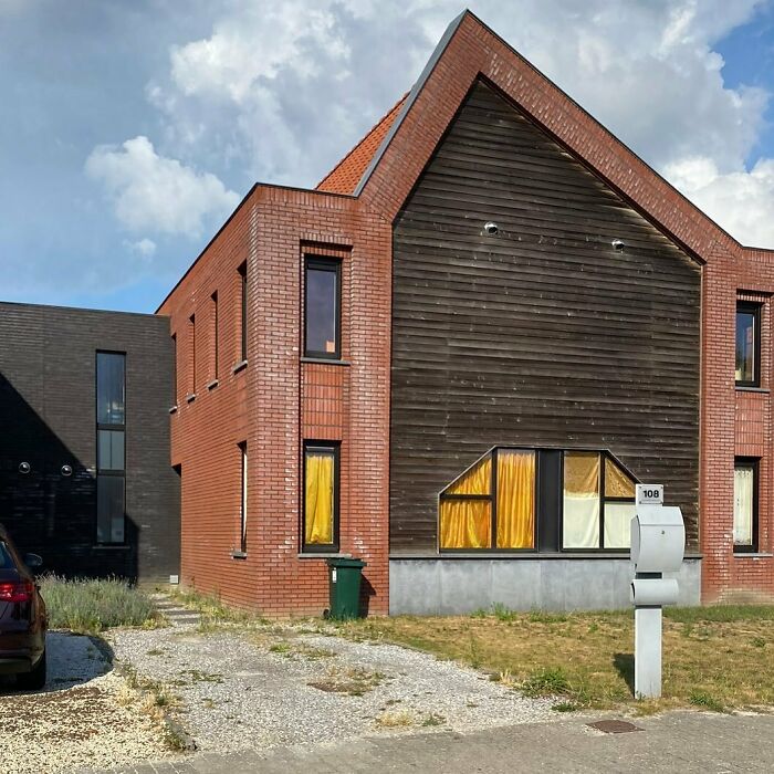 Unusual brick house design with mismatched windows, part of hilariously bad houses collection.