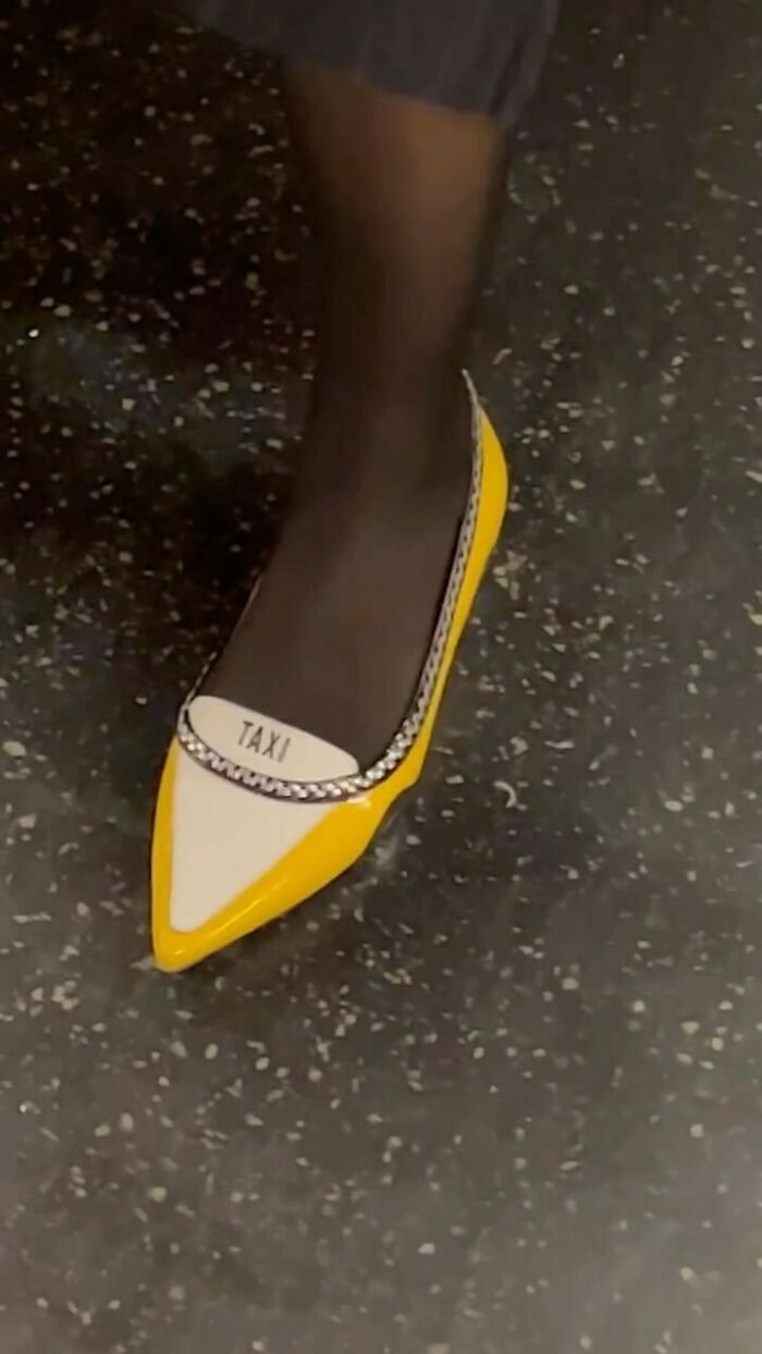 Yellow and white pointed shoe with "TAXI" text worn by a New York local experimenting with fashion.