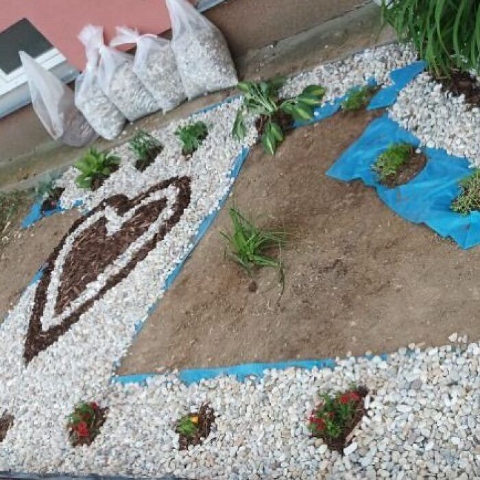 Unique garden design with heart-shaped mulch and white pebbles.