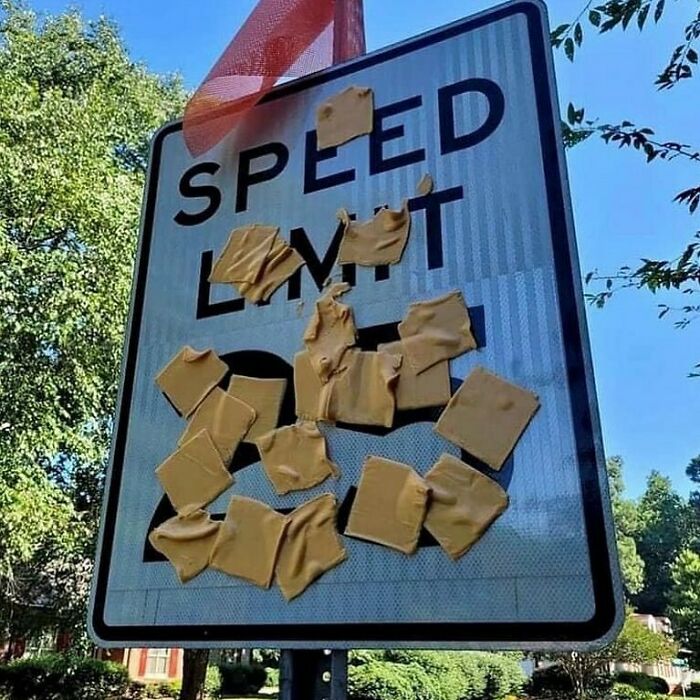 Confusing and funny photo of a speed limit sign covered with cheese slices.