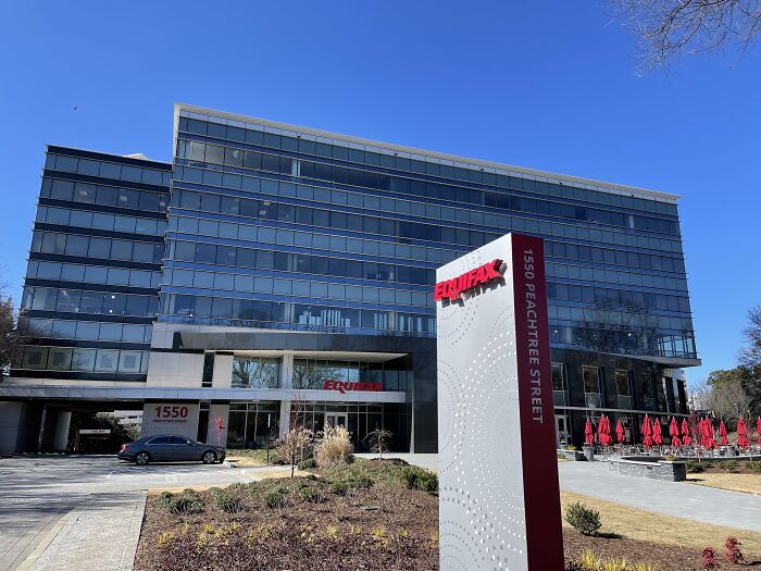 Modern office building with Equifax sign, clear sky, and landscaped surroundings, related to overlooked historical events.