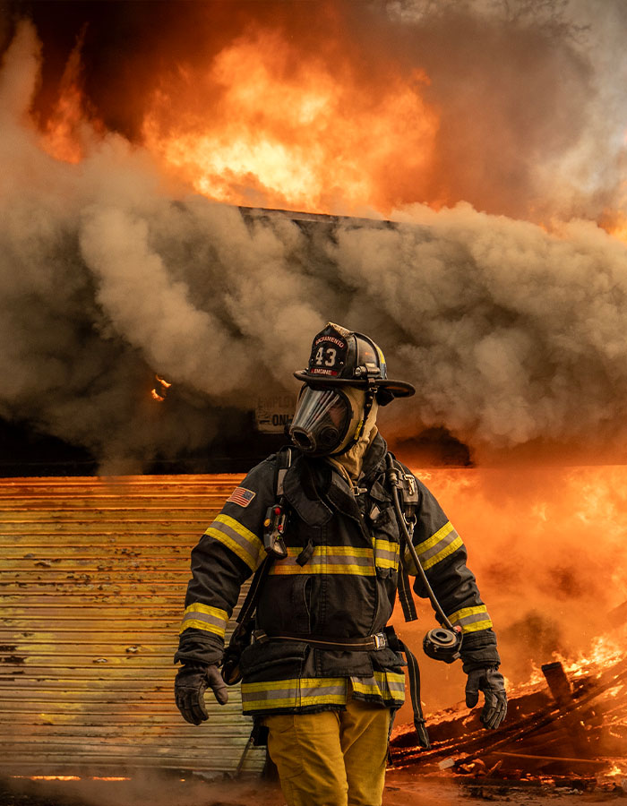 Firefighter in protective gear battling a large blaze, demonstrating heroic efforts in LA.