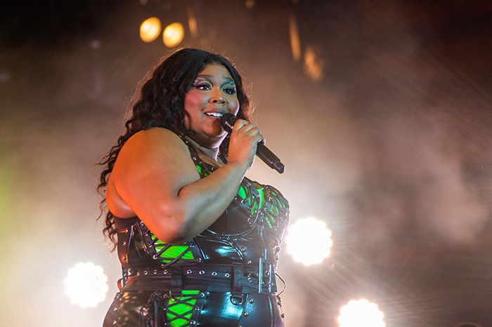 Lizzo performing confidently on stage, wearing a stylish outfit. Lizzo performing confidently on stage, wearing a stylish outfit.
