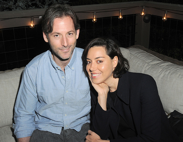 Aubrey Plaza and late husband Jeff Baena sitting on a couch under string lights. Aubrey Plaza and late husband Jeff Baena sitting on a couch under string lights.