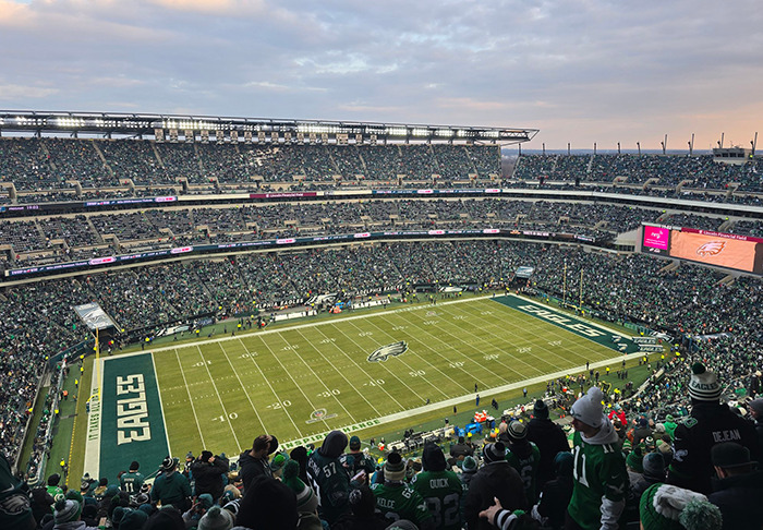 Sports fans at a crowded stadium during a game, with the field and stands visible, showcasing fan enthusiasm.