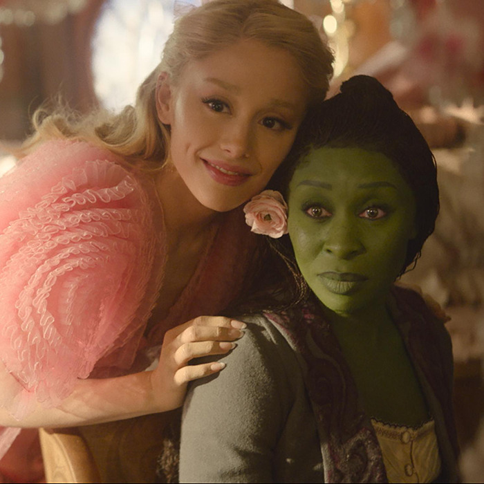 Cynthia Erivo and Ariana Grande costume, one with green makeup, embrace in a whimsical setting. Cynthia Erivo and Ariana Grande costume, one with green makeup, embrace in a whimsical setting.