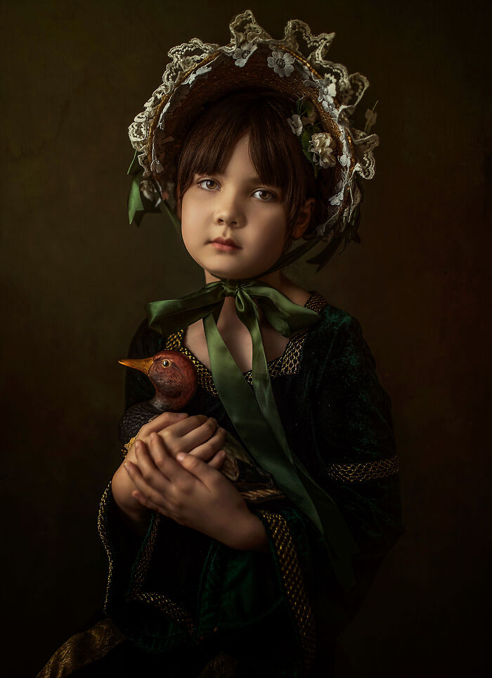 Child in vintage attire holding a bird doll, part of creative photo series battling depression post-divorce.