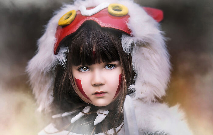 Child in a costume with fur and red accents, part of a creative photography series.