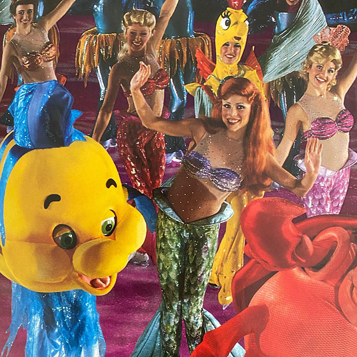 Performers in colorful costumes during a "Disney On Ice" show, featuring characters from an underwater themed scene.