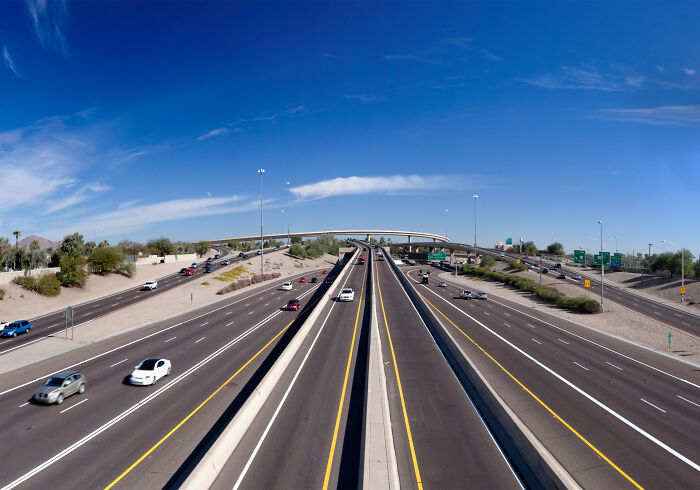 An expansive freeway interchange under a clear blue sky, highlighting modern transport infrastructure.