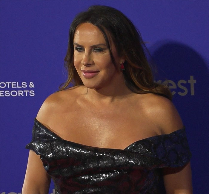 Transgender Oscar nominee in a black dress at an event, facing criticism over past posts and issuing an apology.