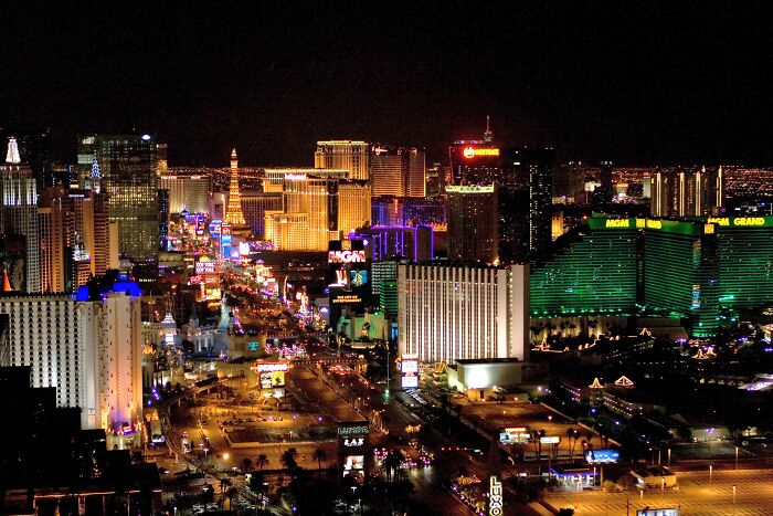 Aerial view of Las Vegas Strip at night, showcasing bright lights and iconic hotels, invoking weird unsolved mysteries ambiance.