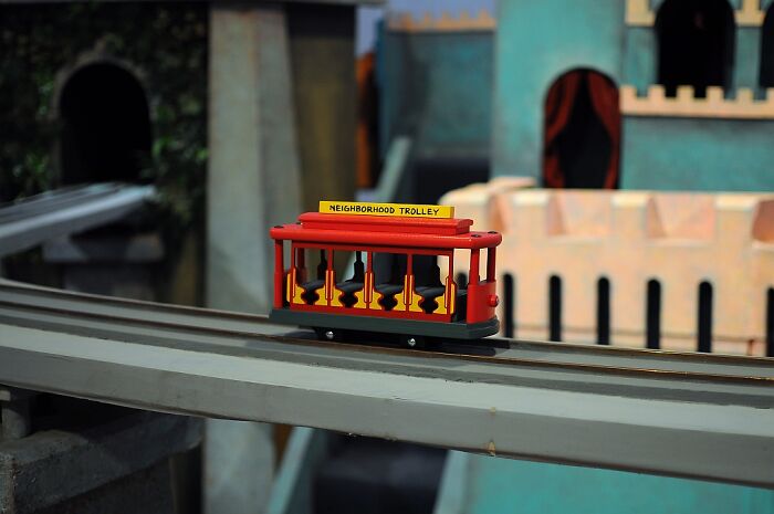 Red toy trolley on a track, part of overlooked historical events display in a model setting.