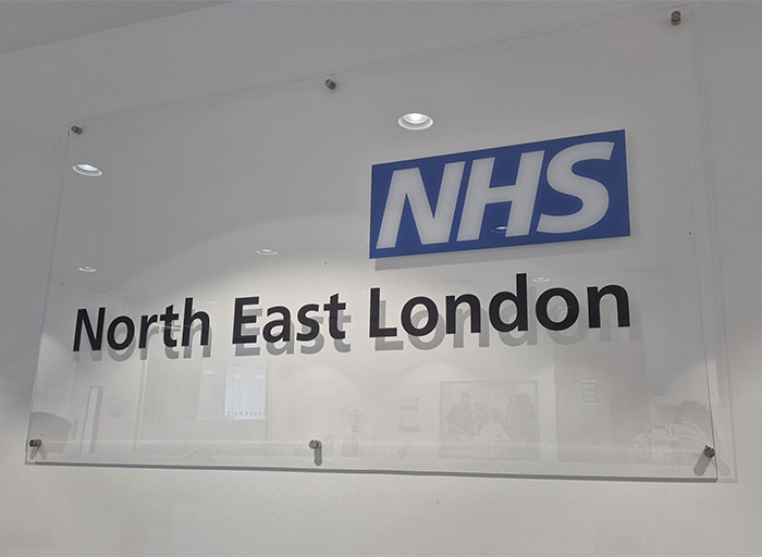 Sign reading "NHS North East London" on a wall, related to breast reduction consultation. Sign reading "NHS North East London" on a wall, related to breast reduction consultation.