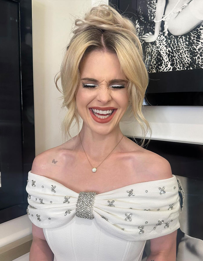 Smiling woman in an off-shoulder dress, representing Hollywood beauty trends and Ozempic discussion. Smiling woman in an off-shoulder dress, representing Hollywood beauty trends and Ozempic discussion.