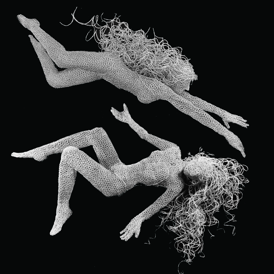 Chicken wire sculptures of two figures in motion on a black background.