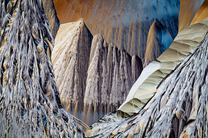 Abstract close-up photograph of colorful, intricate patterns resembling a mountainous landscape.