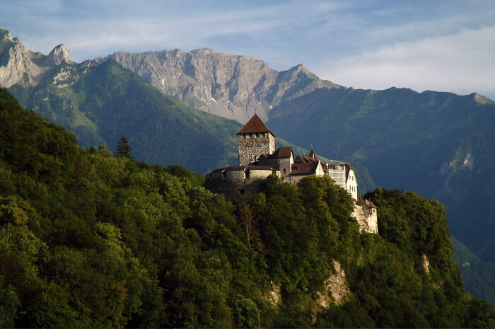 A castle nestled in lush green mountains, representing overlooked historical events.