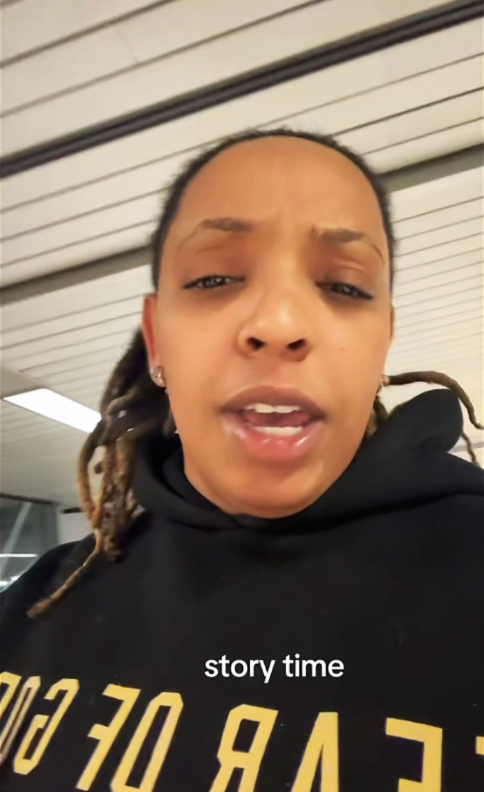 Black woman discussing an incident on a flight, wearing a black hoodie indoors. Black woman discussing an incident on a flight, wearing a black hoodie indoors.