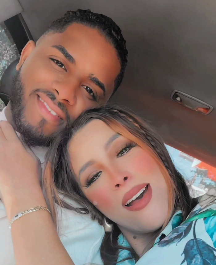 Couple smiling together in a car, facing the camera, capturing a happy moment.