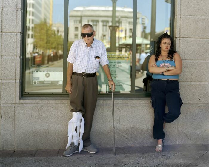 Two people waiting at an urban bus stop, capturing everyday life at America’s bus stops in a city setting.