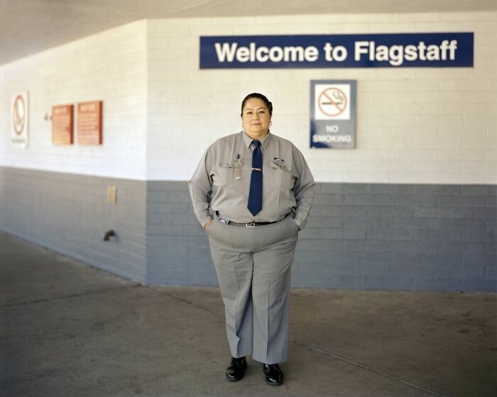 Bus driver standing at Flagstaff bus stop, captured in a photo documenting life at America’s bus stops.
