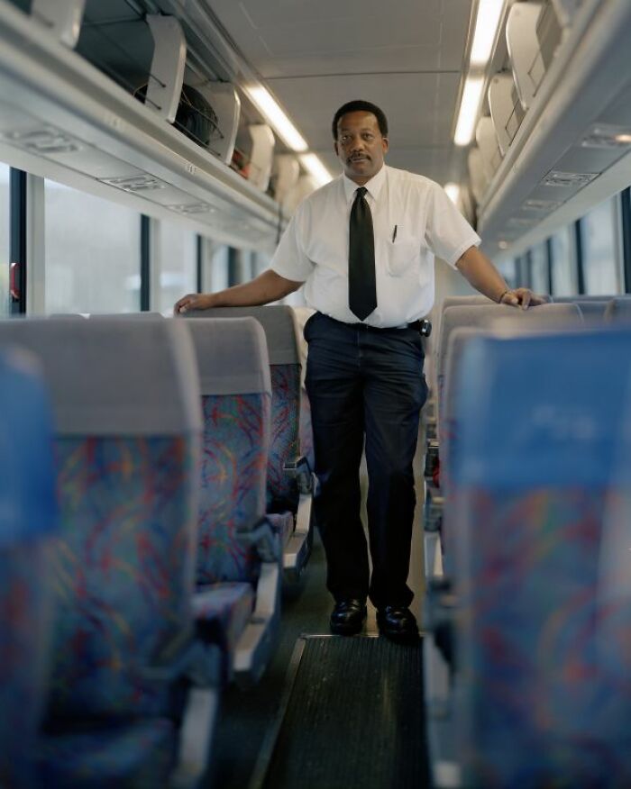 Man in white shirt and black tie standing inside an empty bus, capturing life at America’s bus stops.
