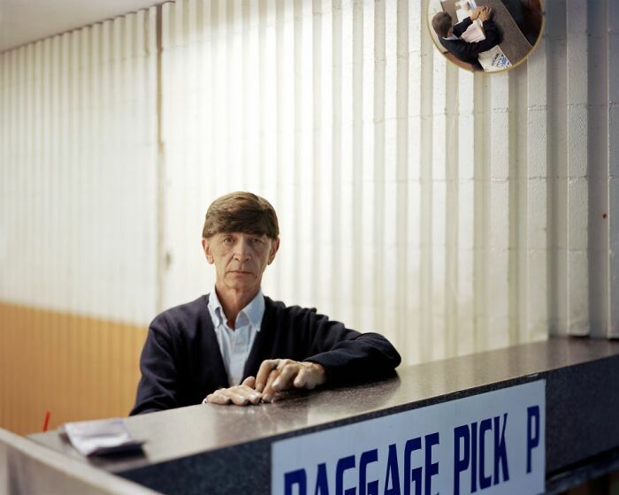 Middle-aged man waiting at a bus station counter, capturing everyday life at America’s bus stops for the See America By Bus series.