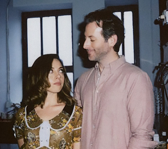 Aubrey Plaza and Jeff Baena standing side by side, looking at each other in a room with natural light. Aubrey Plaza and Jeff Baena standing side by side, looking at each other in a room with natural light.