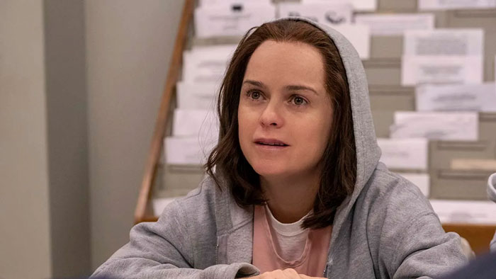 Orange Is The New Black actress in a gray hoodie, appearing thoughtful in a casual setting.