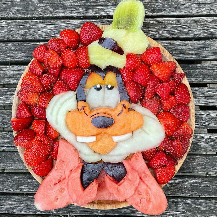 Fruits arranged in a creative artwork resembling a character, emphasizing healthy eating as art.