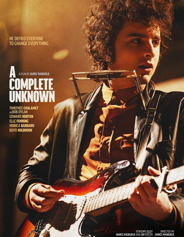Timoth&eacute;e Chalamet as Bob Dylan in "A Complete Unknown," holding a guitar.