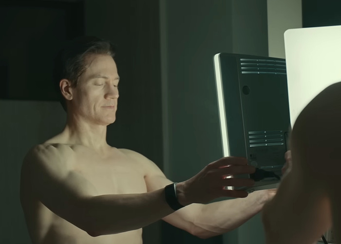 Bryan Johnson examining skin in the mirror, illustrating effects of longevity medication from Project Baby Face mogul.