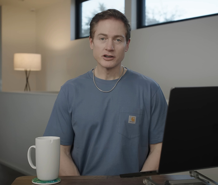 Project Baby Face mogul in casual setting with a laptop and mug.