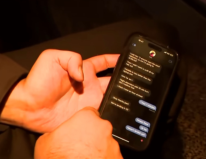 Hands holding a phone displaying a text conversation related to a plane crash.