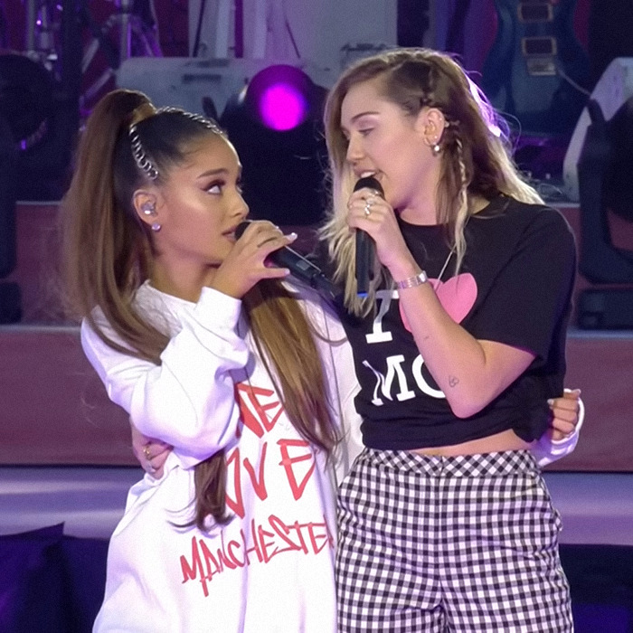 Miley Cyrus performs in a see-through top during a live concert with Ariana Grande.