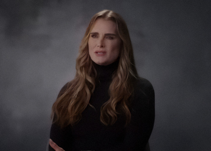 Brooke Shields in a dark turtleneck speaking in an interview setting.