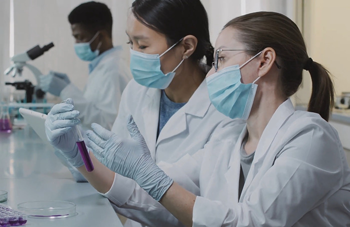 Scientists in lab coats examine a sample, relating to freezing bodies for future revival.