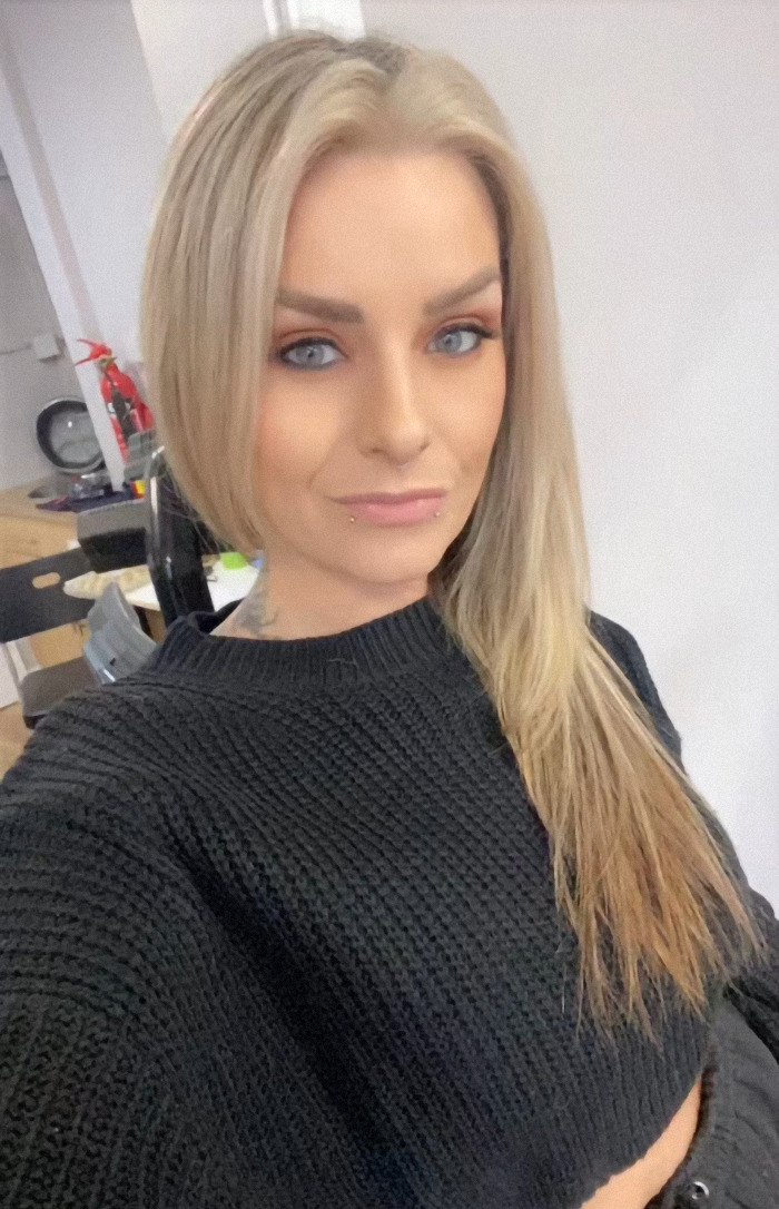 Kelly Wynne with long blonde hair in a dark sweater smiling, representing weight loss transformation success. Kelly Wynne with long blonde hair in a dark sweater smiling, representing weight loss transformation success.