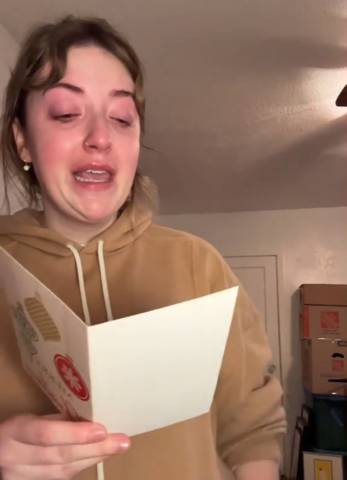 Madison Vaughan holding a card, emotional farewell to longtime mailman before moving out. Madison Vaughan holding a card, emotional farewell to longtime mailman before moving out.