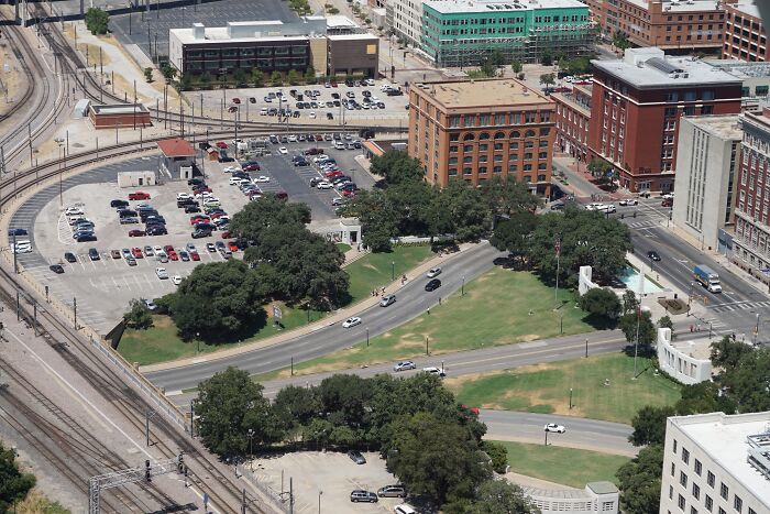 Aerial view of Dealey Plaza, the site of a weird unsolved mystery, showing roads, buildings, and parked cars.