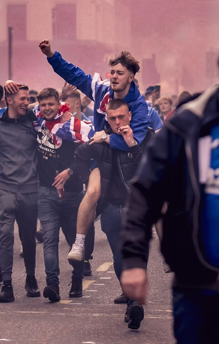Young men celebrating with flags in street, an award-winning photo from The Artist Gallery Awards 2024.