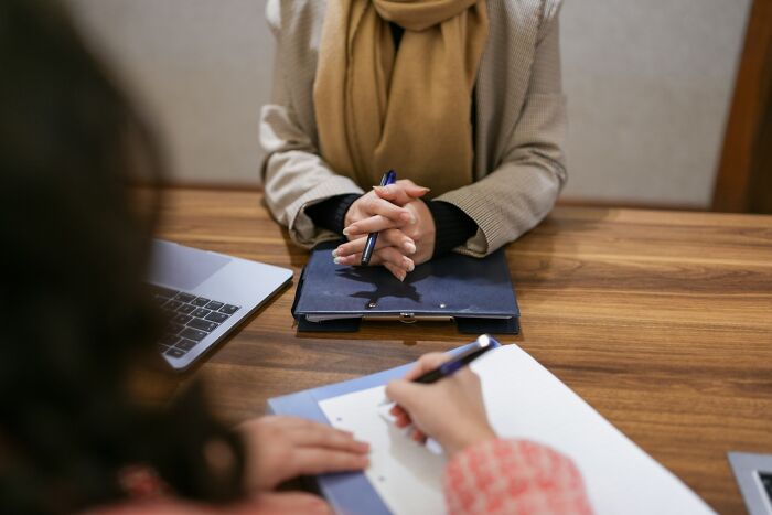 Two people discussing high-paying remote jobs over a laptop and notepad in a meeting room.