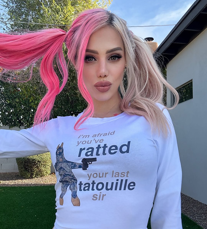 Woman with pink hair in a playful shirt.