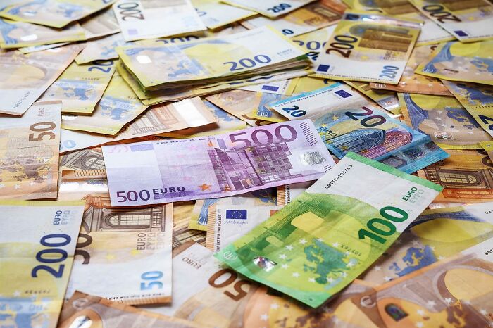 Euro banknotes scattered as a representation of slashing household budgets smartly without feeling broke.