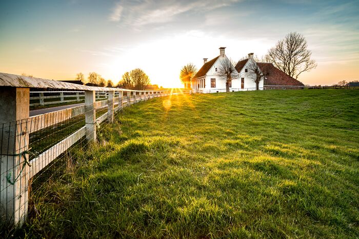 A serene countryside house at sunset.