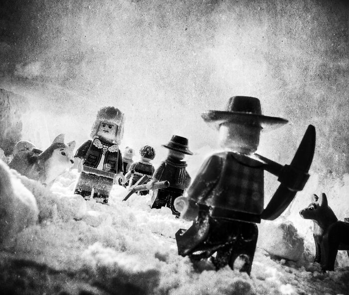 LEGO figures depict an Antarctic expedition scene with explorers and husky dogs in the snow.