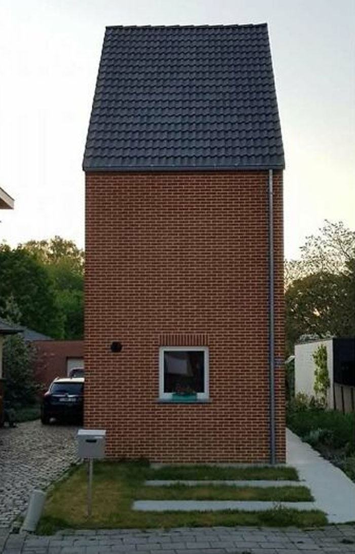 Tall, narrow brick house with one window, epitomizing hilariously bad house design.
